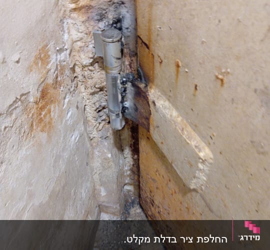 צילינדר מתכת מותקן על דלת עץ ישנה